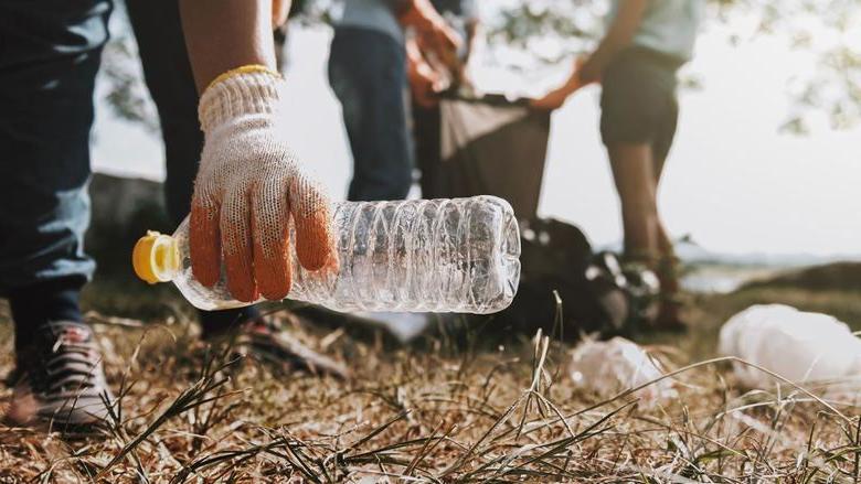 a group of people picking up litter alongside a street