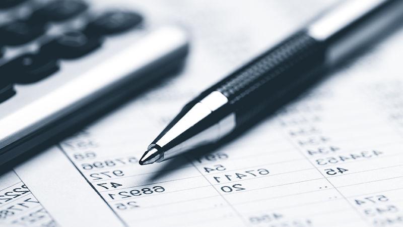 A pen and a calculator on top of tax documents