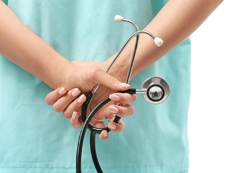 a nurse holding a stethoscope behind her back